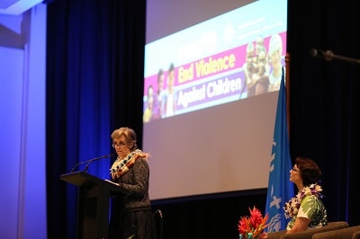 An image of one of the female keynote speakers at the Ending Violence Against Children conference as she gives a speech on stage.